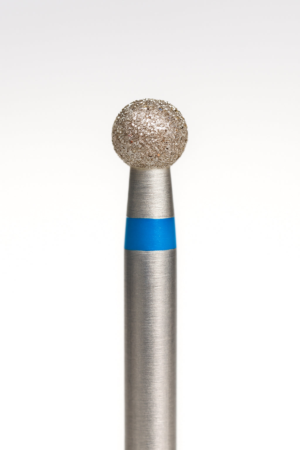 La peau rugueuse est travaillée avec un embout ponceuse diamant en forme de bille, abrasivité moyenne (bleu)
